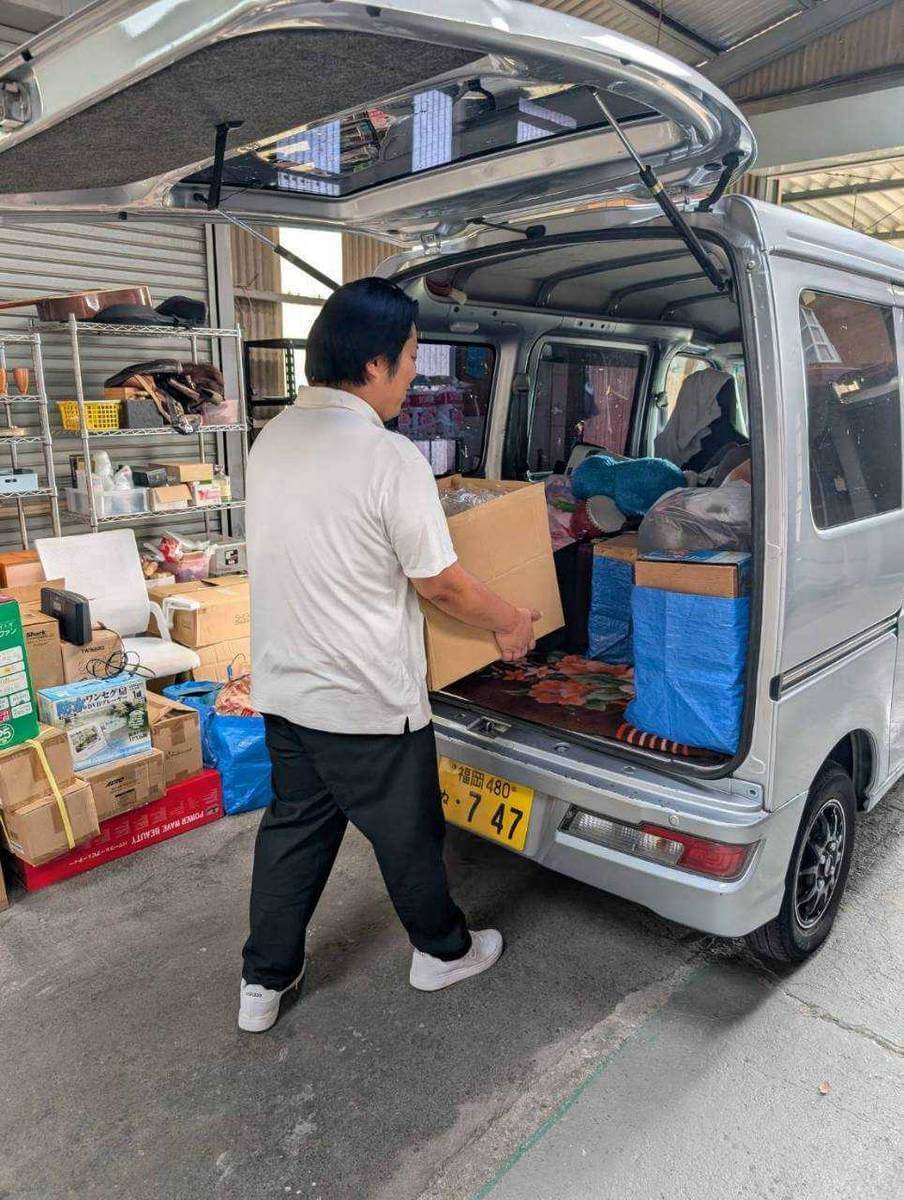 かいとり隊スタッフが段ボール箱にまとめた買取品を車両へ積み込む作業風景